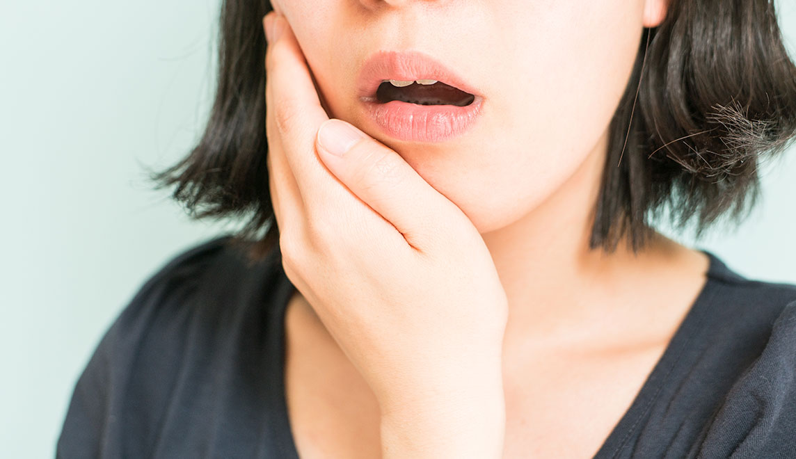 歯を抑える女性